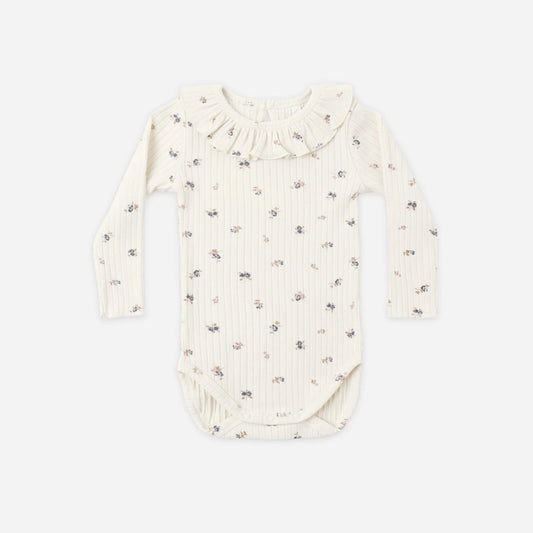 An off-white long-sleeve baby bodysuit with a delicate, small all-over floral print, featuring a ruffled collar and ribbed texture, laid flat against a light gray background.