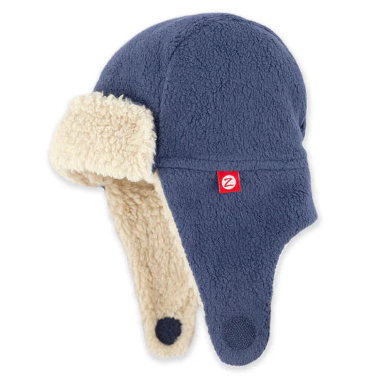 Blue winter hat with beige earflaps on a white background