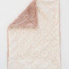 Blanket with textured surface and pink lush underside