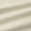 A close-up of a light cream or off-white textured fabric with soft folds and a linen-like weave.