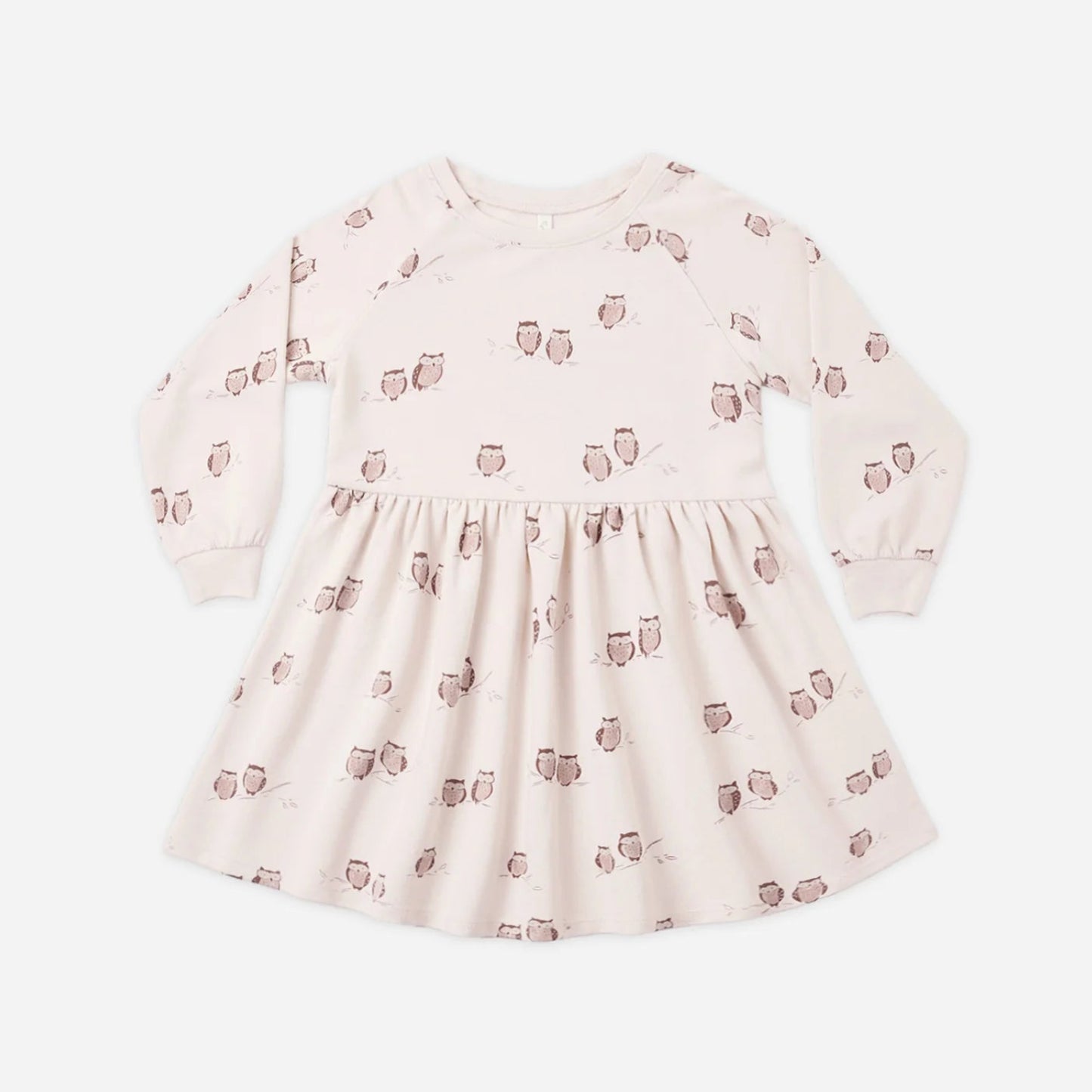 A long-sleeve baby dress in a very pale blush pink with a repeating brown owl print, displayed flat against a light gray background.