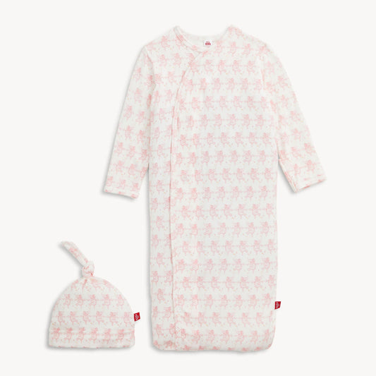 Baby onesie with pink floral pattern and matching hat on a white background