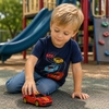 Child in navy tee with race car graphic, playing with toys at a playground