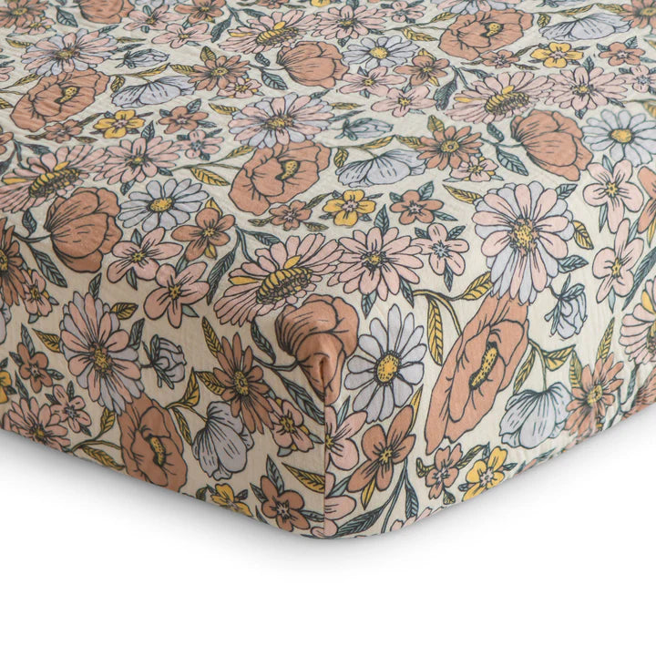 Floral patterned fabric with pink, blue, and yellow flowers on a beige background