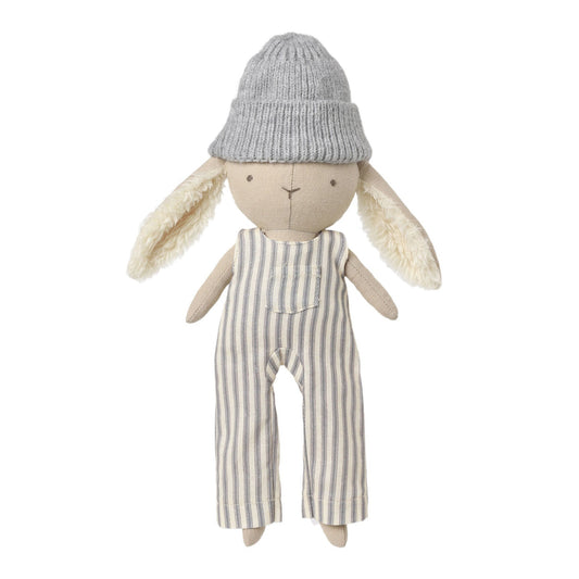 A plush stuffed bunny doll wearing a gray knit beanie and cream-and-gray vertically striped fabric jumpsuit, centered on a plain light background.