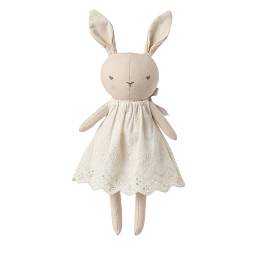 A plush bunny doll wearing a cream-colored embroidered dress, centered on a solid white background.
