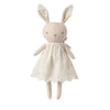 A plush bunny doll wearing a cream-colored embroidered dress, centered on a solid white background.