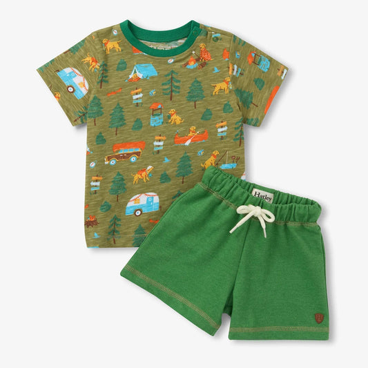 Children's outfit with patterned shirt and green shorts on a white background