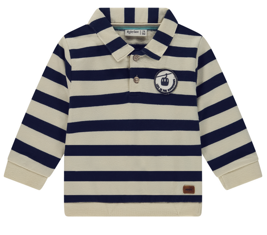 A striped collared top featuring navy and beige colors with a ski gondola patch on the chest.