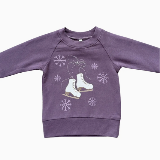 Purple sweatshirt with ice skate and snowflake design on a white background