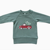Green sweatshirt with a red truck graphic on a white background