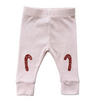 Baby leggings with candy cane designs on a white background
