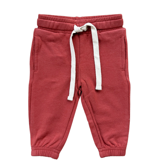 Red sweatpants with a white drawstring on a white background