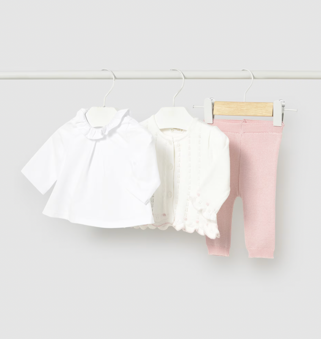 Baby girls three-piece set including a white shirt, pink pants, and a white cardigan on a rack against a white background.
