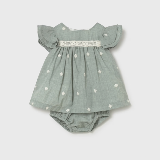 Green baby dress with ruffled sleeves and daisy patterns with a diaper cover. 