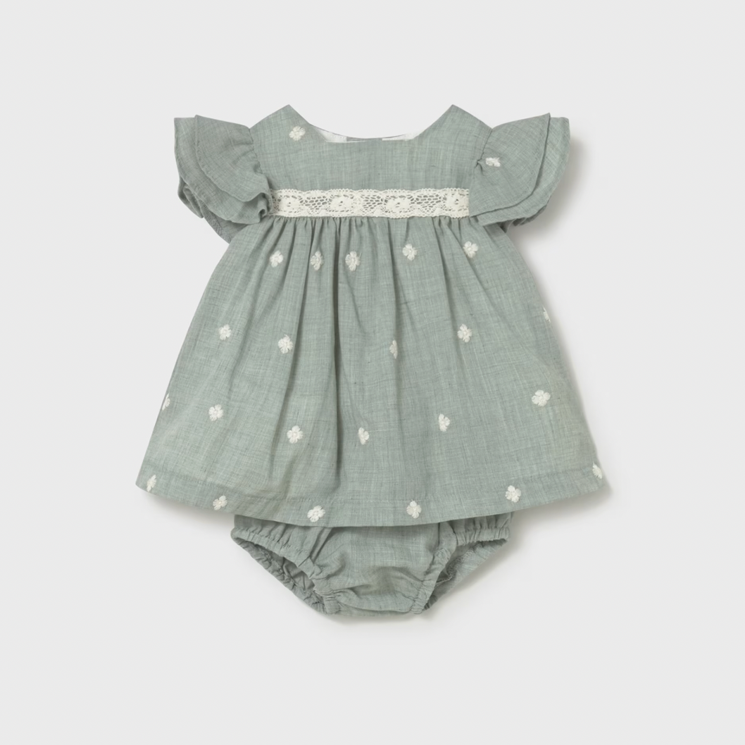 Green baby dress with ruffled sleeves and daisy patterns with a diaper cover. 