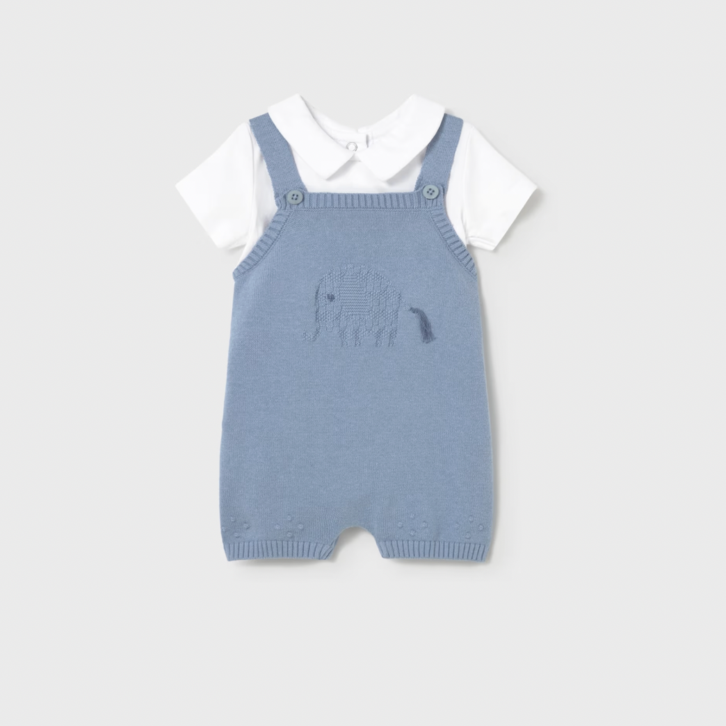 Blue knitted romper with white shirt on a light gray background