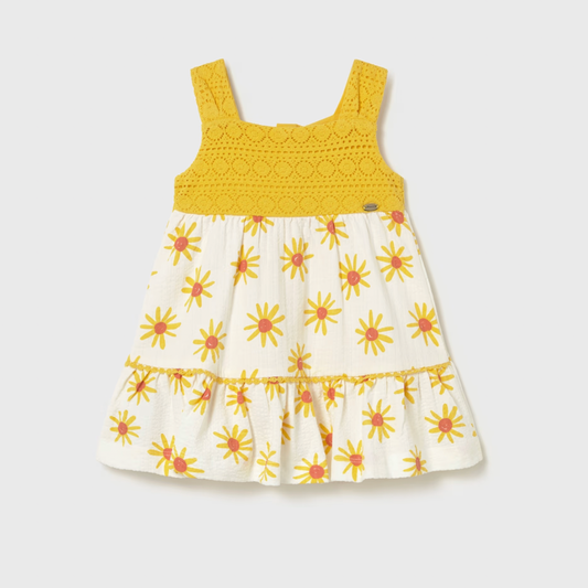 Yellow and white dress with floral pattern on a light gray background