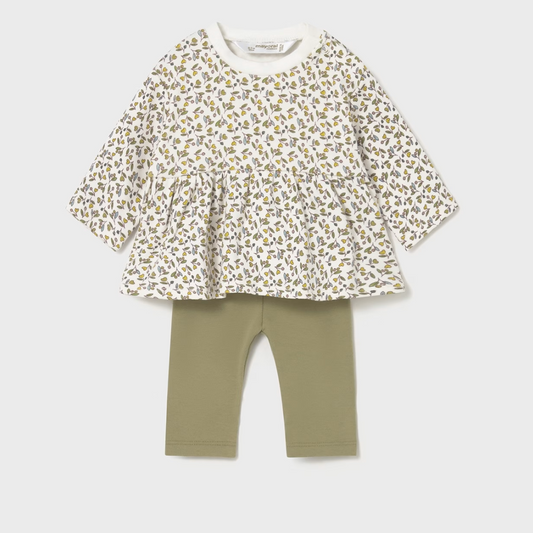 Children's outfit with floral top and green leggings on a light gray background