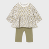Children's outfit with floral top and green leggings on a light gray background