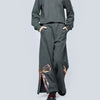 Person wearing gray sweatshirt and gray sweatpants with decorative sequin bow