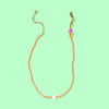 Necklace with colorful beads on a light green background
