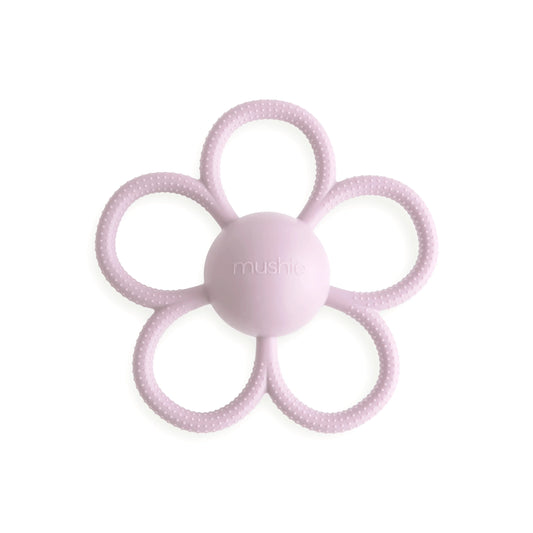 A silicone daisy-shaped rattle teether in lilac color with a central ball for teething and handles shaped like petals.