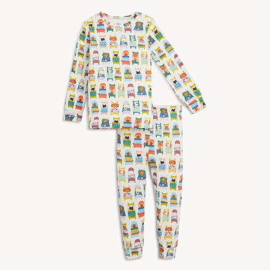 A two-piece children's pajama set featuring a long-sleeve top and matching pants, both printed with a colorful repeating pattern of cartoon characters and vehicles on a white background.