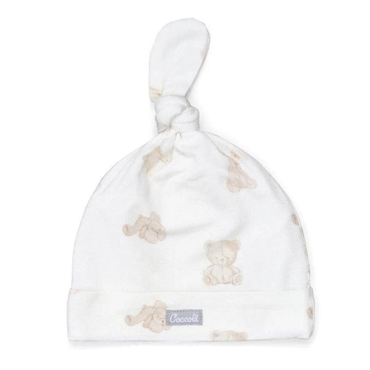 White baby hat with teddy bear pattern and Coccetti logo on a white background