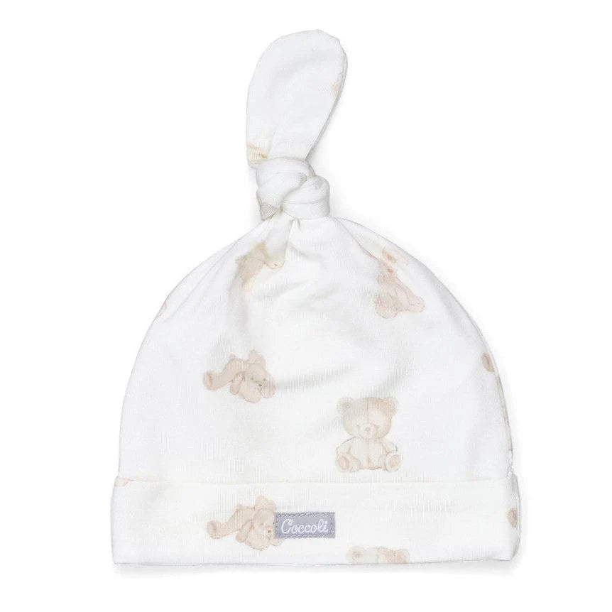 White baby hat with teddy bear pattern and Coccetti logo on a white background