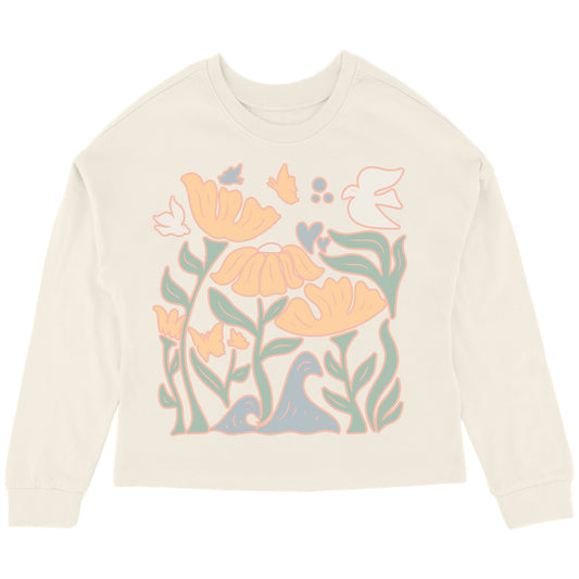 An oversized top with a floral graphic design in multicolor on a beige background.