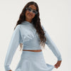 Girl wearing a light blue dolman sleeve hoodie with matching skirt