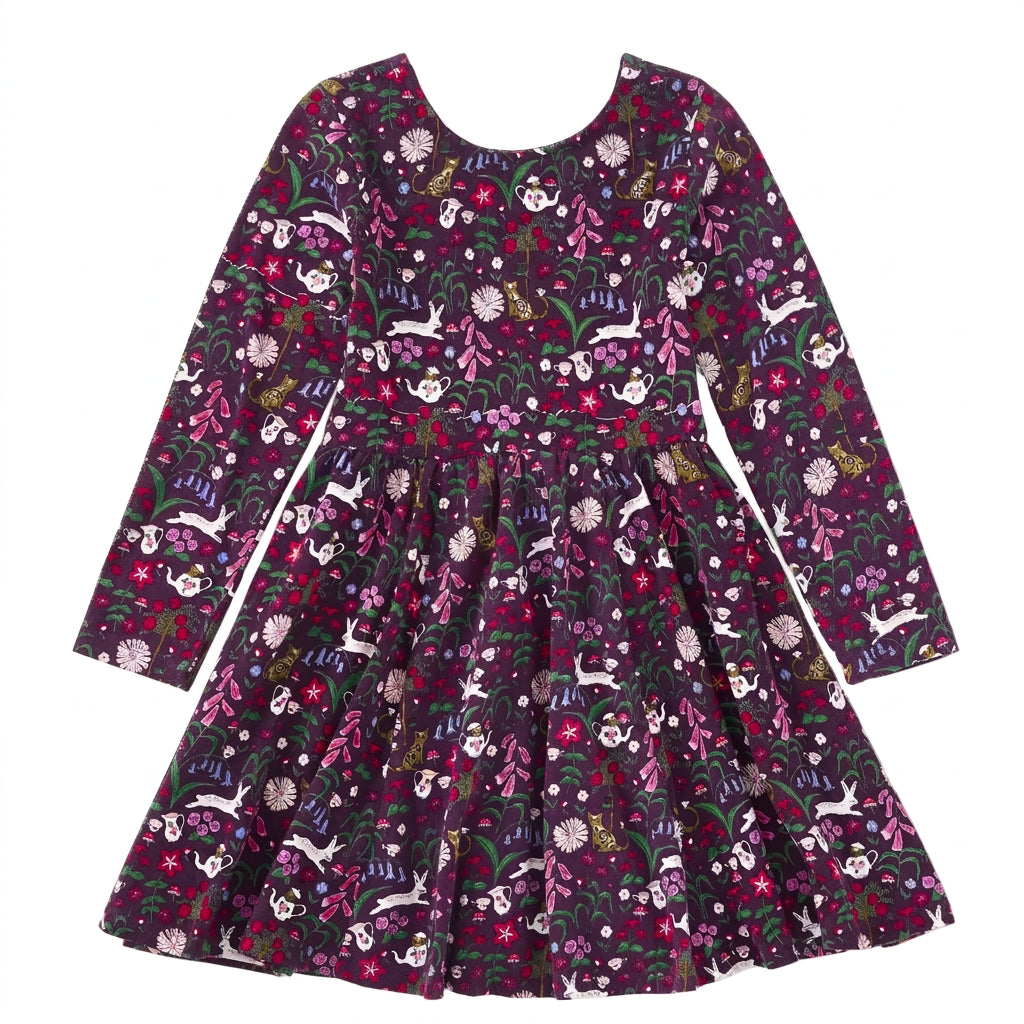 A long-sleeve children's dress with a dark purple and black base, covered in a whimsical floral and animal print featuring rabbits, flowers, and butterflies in pink, white, green, and yellow.