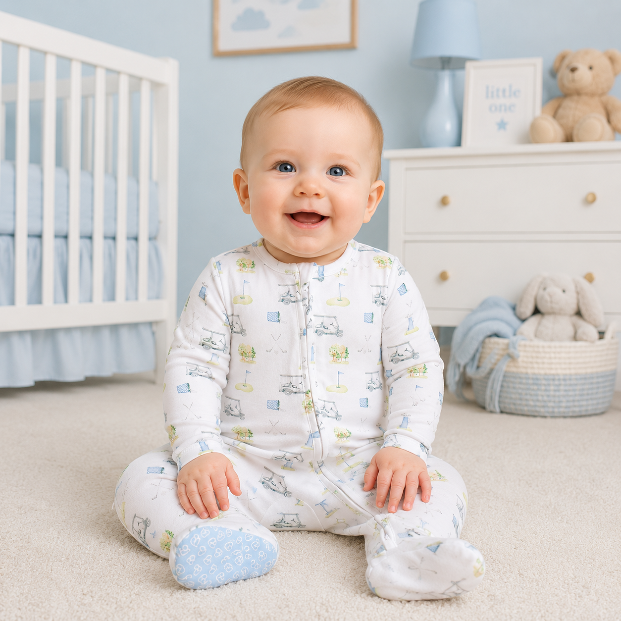 Baby in a white zipper footie pajama with a golf theme all-over printer