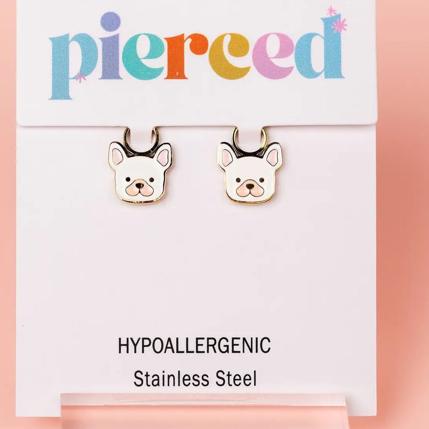 Dog-shaped earrings on a 'pierced' branded card with hypoallergenic information.