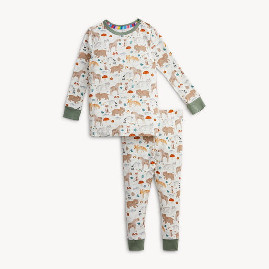 A two-piece children's pajama set featuring a long-sleeve top and matching pants with an all-over woodland animal print on an off-white background. The set has sage green cuffs and hem, and a small rainbow pattern on the inner collar.