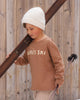 Child outdoors wearing the Apres Ski Raw Edge Top with the apres-ski print