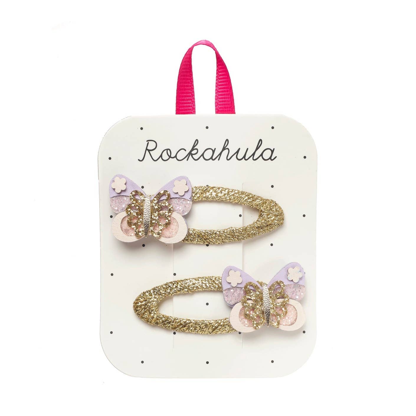 A set of two gold glitter hair clips with pastel purple and pink butterfly embellishments, presented on a white display card with a pink ribbon loop at the top. The card is branded 'Rockahula'.