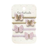 A set of four children's hair accessories on a white display card. The set includes two lavender and gold glitter butterfly hair clips, one lavender and gold glitter butterfly hair pin, and one lavender and white polka dot elastic hair tie, all attached to a white card printed with the brand name 'Rockahula'.