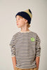 Child wearing a striped shirt and beanie with a logo on a plain background