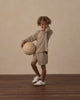 Child playing outdoors in the Heather Olive Pocket Tee