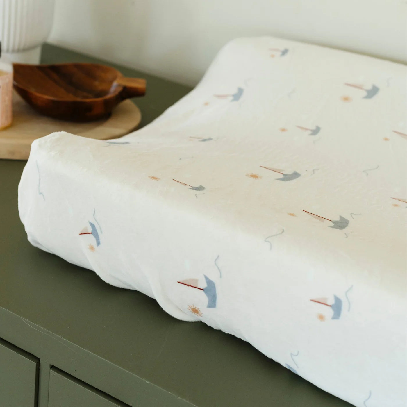 Cushion with bird pattern on a green surface