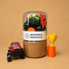 Jar of brown dough with toy cars and a trophy on a beige background, featuring Magnolia Dough Co. branding.