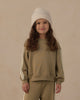 Child wearing the olive oversized sweatshirt with lace trim