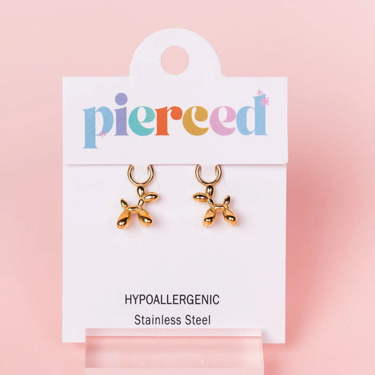 Gold balloon dog earrings on a 'pierceed' branded card with a pink background