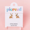 Gold balloon dog earrings on a 'pierceed' branded card with a pink background
