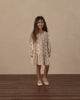Child playing outdoors in the Pink Daisies Swing Dress