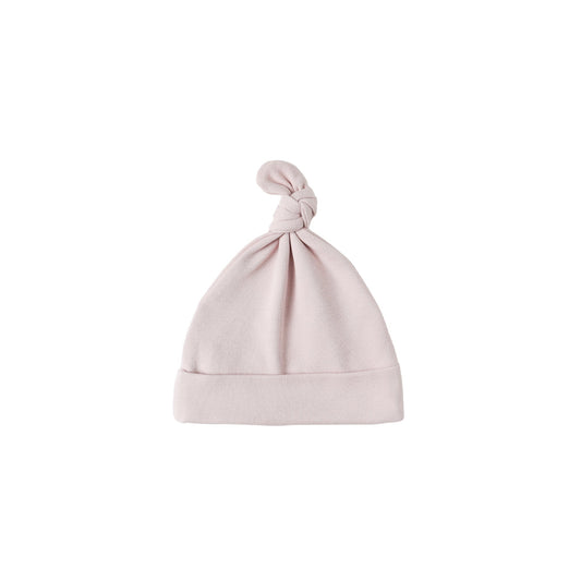 Pink baby hat with a knot on top against a white background