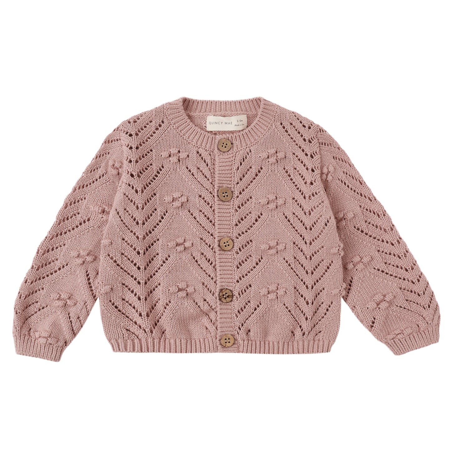 Pink knitted cardigan with button details on a white background