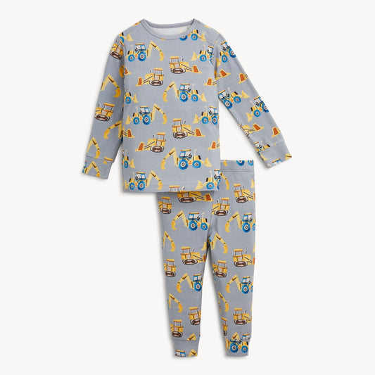 A two-piece children's pajama set featuring a light gray long-sleeve top and matching pants, both printed with a repeating pattern of yellow construction vehicles like tractors and excavators.